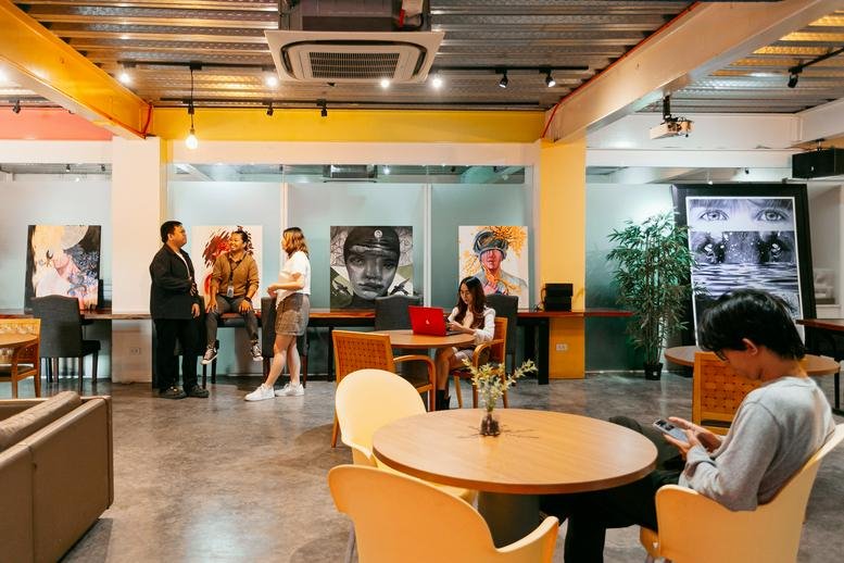 Spacious communal lounge with diverse seating, warm lighting, and framed artwork.