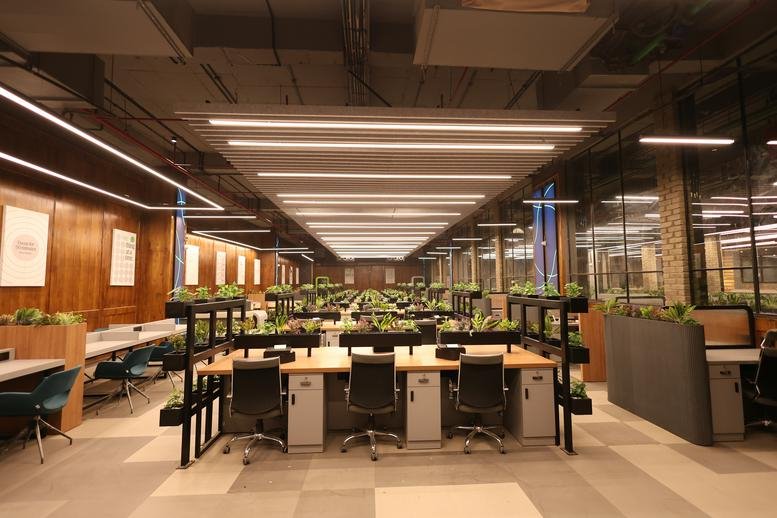 Spacious open-plan workspace at Galaxy Blue Sapphire Plaza with long rows of desks and indoor plants.