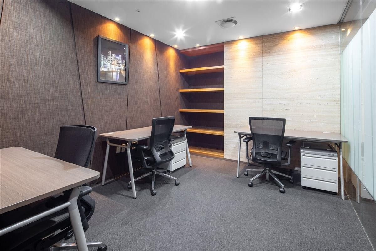 A private three-person office suite at Gangnam Building with dark wood-paneled walls and a built-in bookshelf.