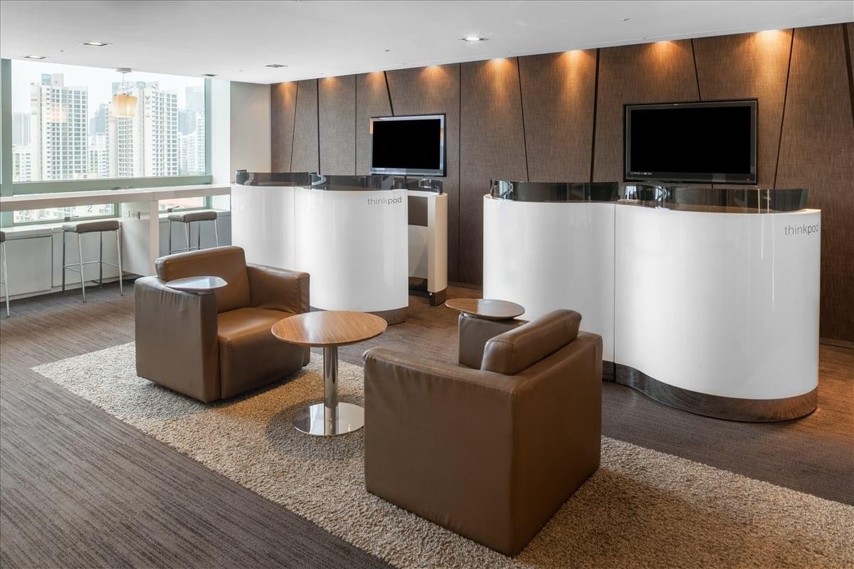 Reception area at Gangnam Building with white curved counters and brown leather armchairs.