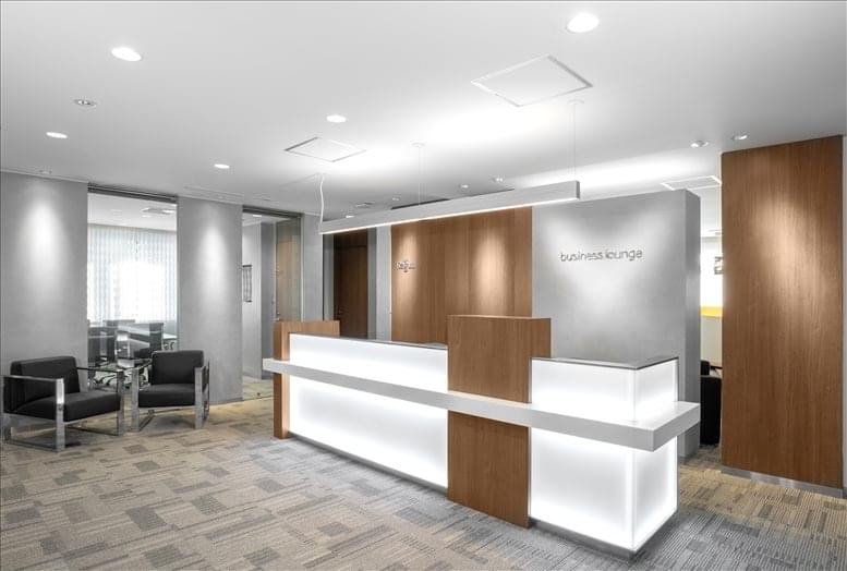 Modern minimalist reception desk with glowing white panels and wood accents.