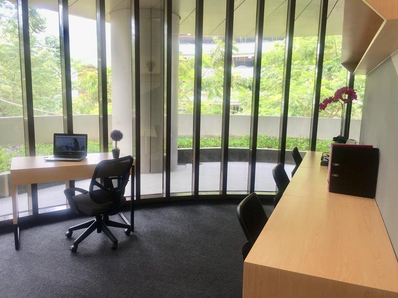 Workspace at Green Office Park, MyRepublic Plaza Wing, A, with a desk and curved floor-to-ceiling windows.