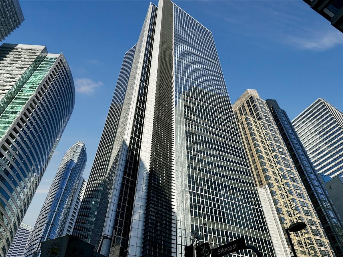 Wide-angle street view of the striking glass skyscraper among city buildings.