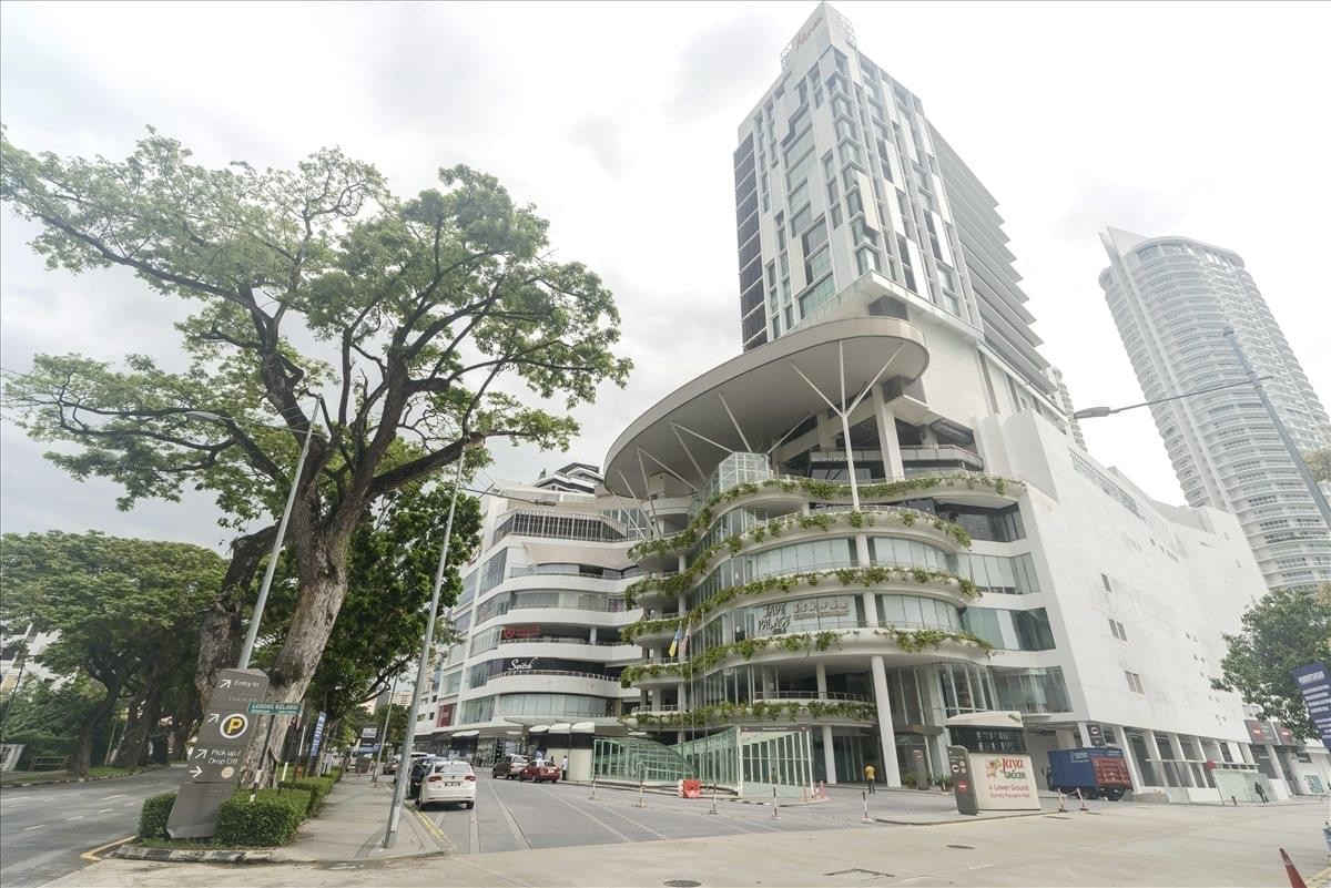 Exterior view of the modern Gurney Paragon Office Tower and surrounding urban greenery.