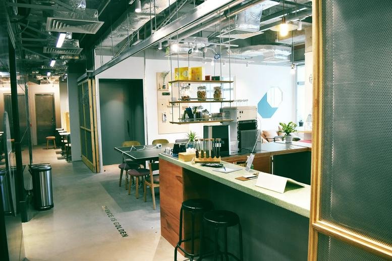 Spacious coworking area with a kitchen bar and cafe seating at Hang Seng Tsuen Wan Building.