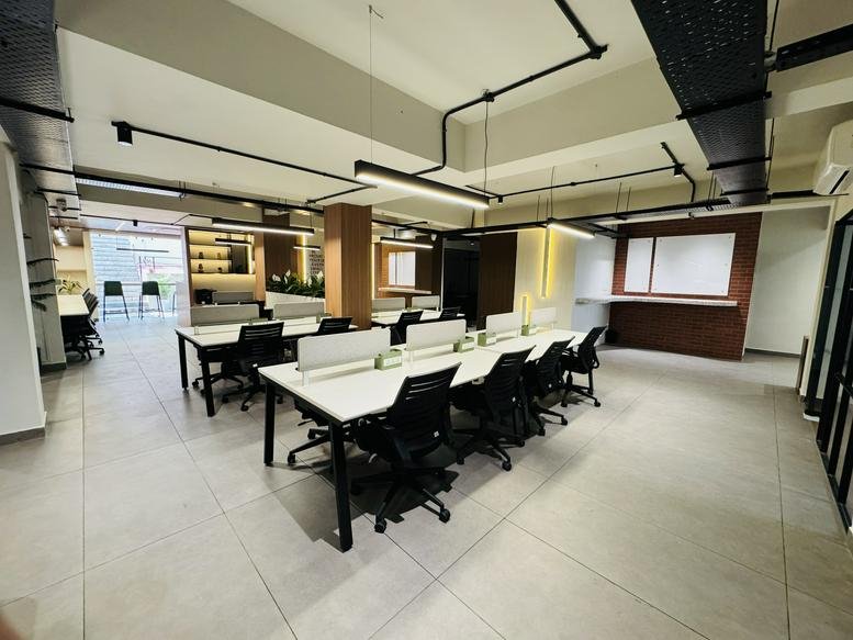 Spacious open-plan workspace at Harisons House with modern white desks and industrial-style lighting.