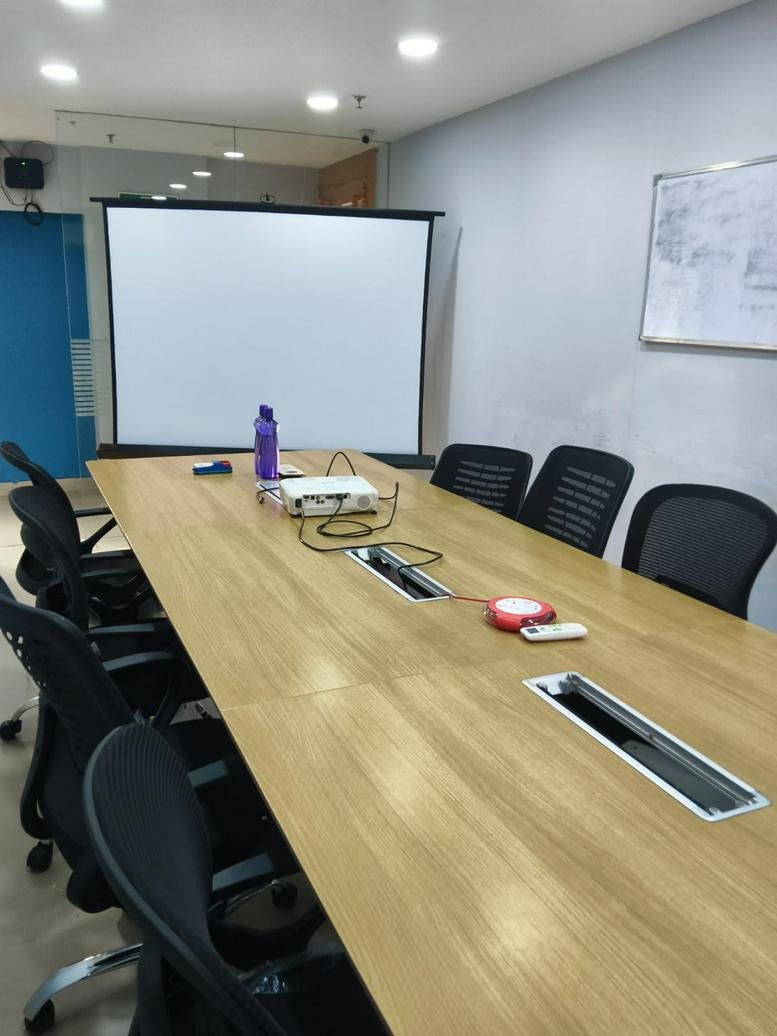 Meeting room at Horizon Building, 4th Floor, Jawaharlal Nehru Road featuring a long wooden table and projector screen.