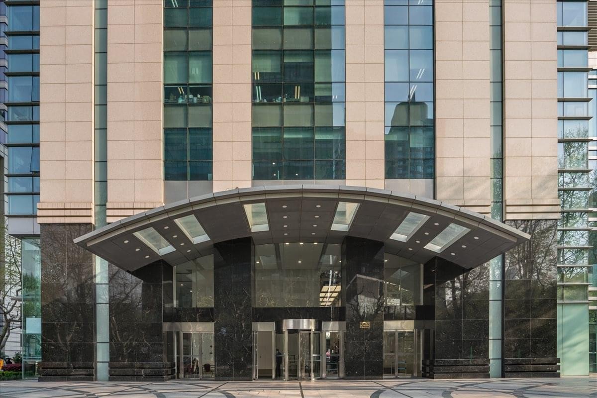 Exterior view of the arched entrance and glass facade of Huaihai Plaza.