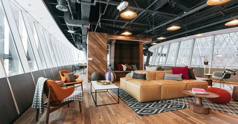Spacious communal lounge with tan leather sofas and modern decor at Iceberg, 6 Chome-12-18 Jingumae.