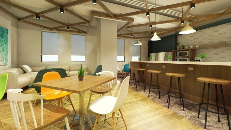 Communal lounge and cafe at Insular Life Building with wooden floors and colorful chairs.