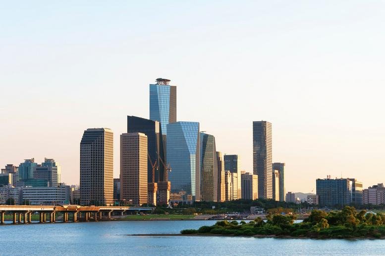 City skyline view featuring the glass-clad skyscraper by the water.