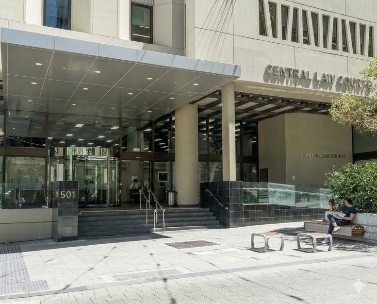 Street-level view of the building entrance with a modern grey awning and concrete steps.