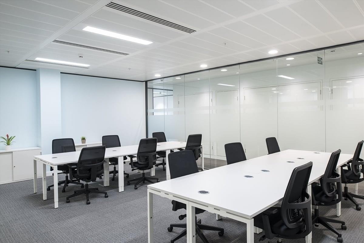 Spacious open-plan workspace at Itami Hankyu Building (Itami Reita) with white desks and black ergonomic chairs.