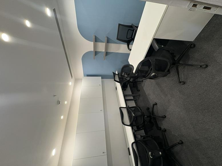 Spacious open-plan workspace at Ithum Tower A with multiple ergonomic chairs and long white desks.
