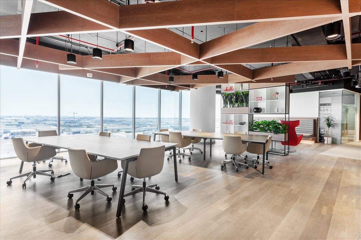 Spacious coworking area with a decorative wooden lattice ceiling and city views.