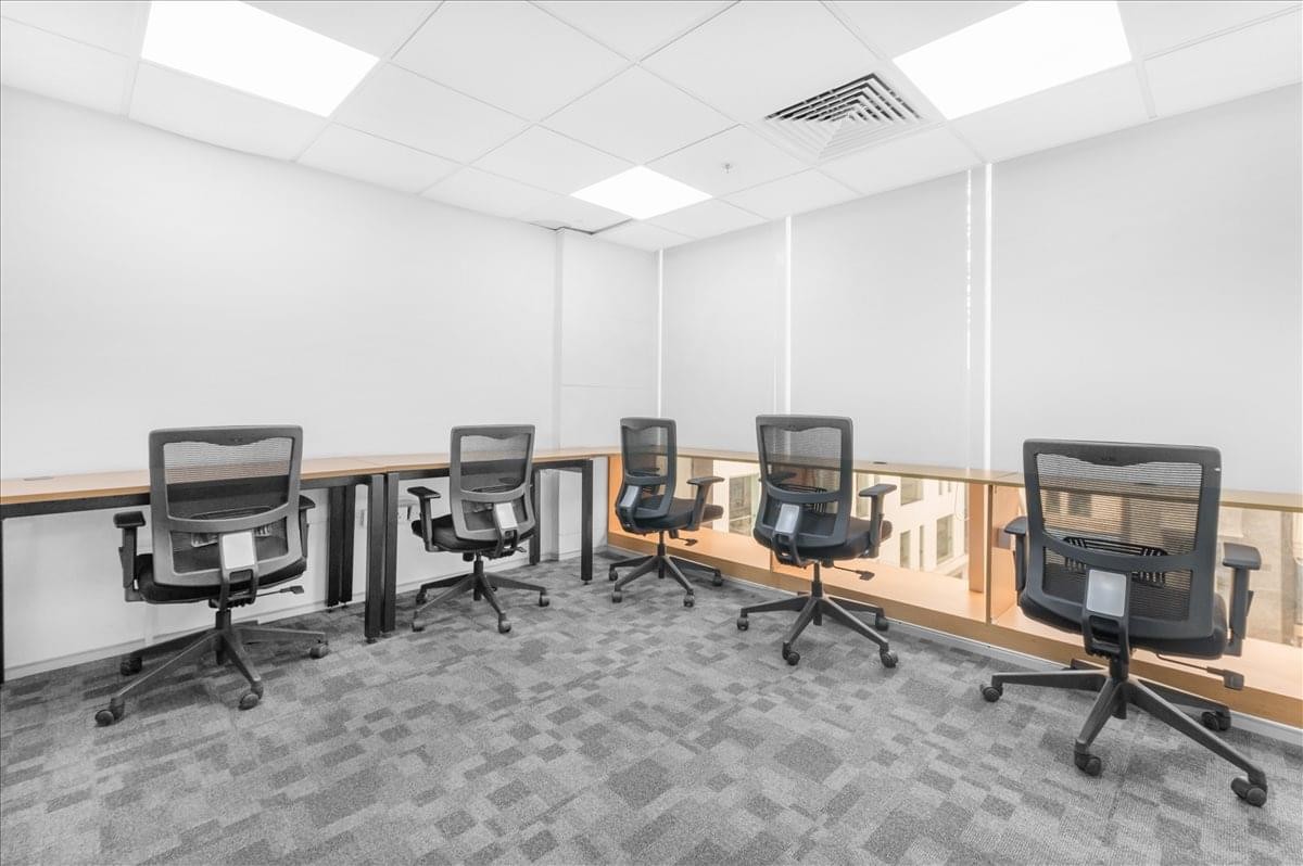 Spacious open-plan workspace at Jaipur Centre featuring several black ergonomic chairs and wooden desks.