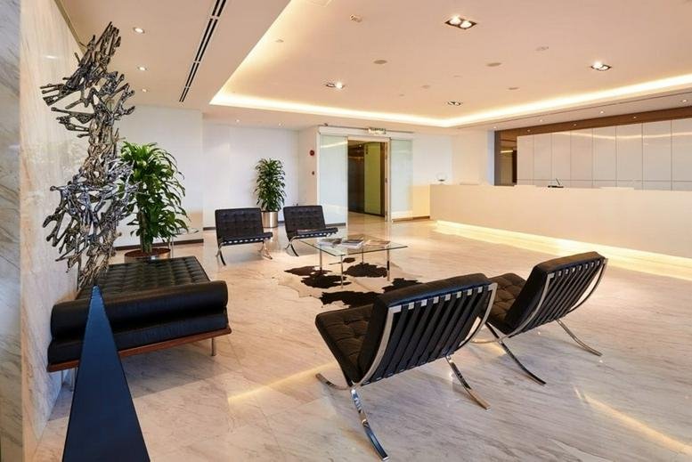 Modern lobby and reception area at Quill 7, featuring designer chairs and contemporary sculpture.
