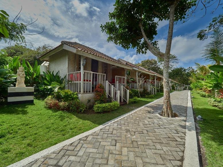 Exterior view of the traditional-style bungalows and stone path at The Tempekan Heritage.