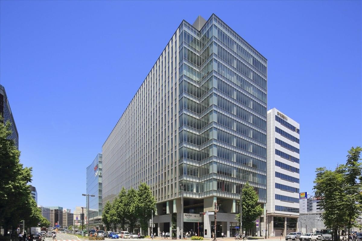 Exterior view of the contemporary glass and steel JR JP Hakata Building facade under a blue sky.