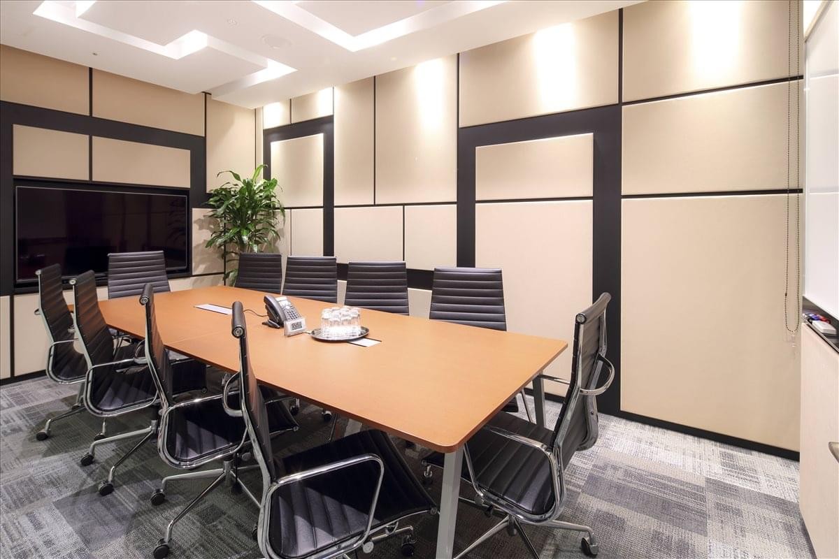 Professional meeting room at JR JP Hakata Building with a large wood-tone table and ergonomic black chairs.
