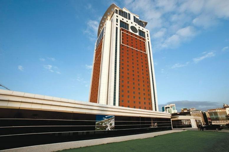 Exterior view of the Flora Suite Office skyscraper with a distinctive red and white facade.
