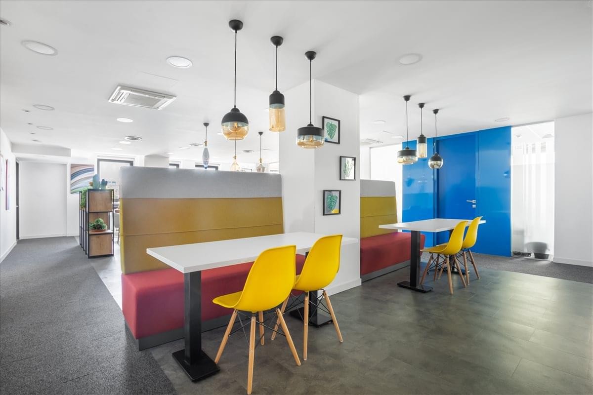 Coworking lounge at Kısıklı Cd No:28, Altunizade with colorful booths and yellow chairs.