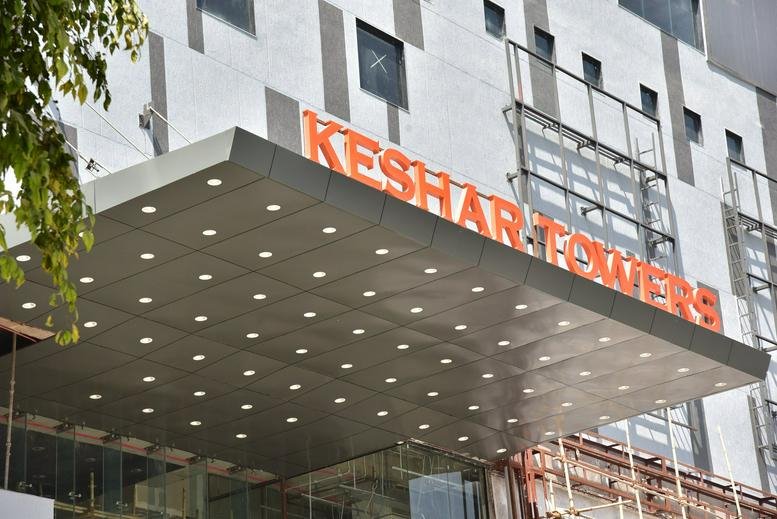 Exterior view of the building facade with the Keshar Towers entrance canopy.
