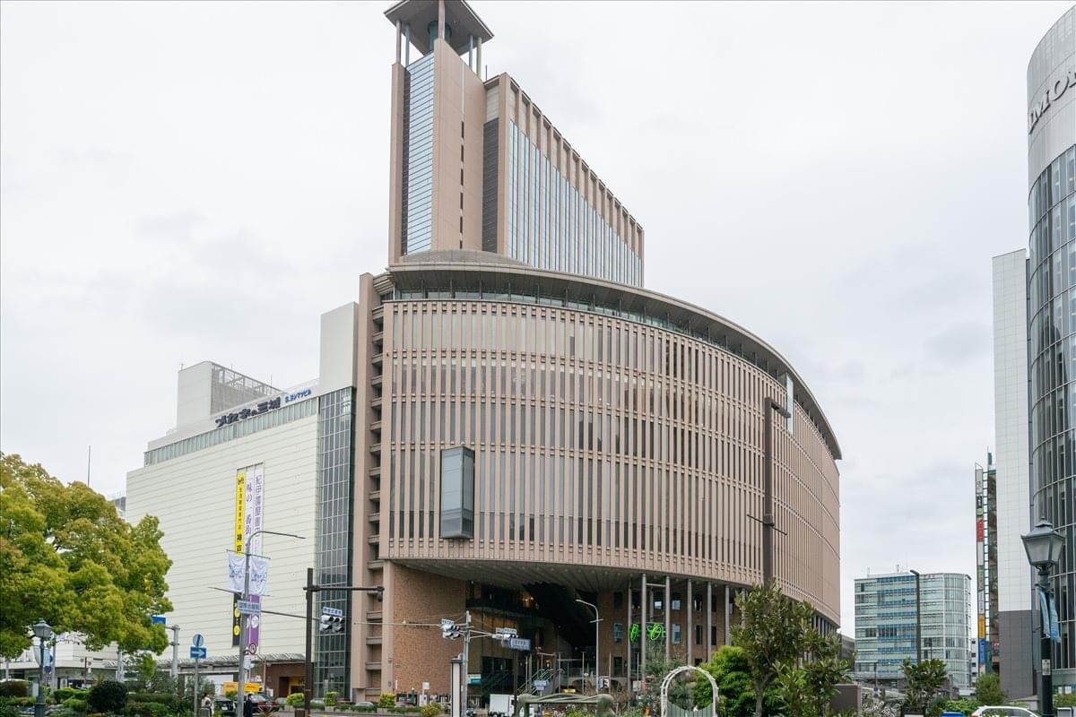 Exterior view of the curved facade and entrance of the Kobe Kokusai Kaikan building.