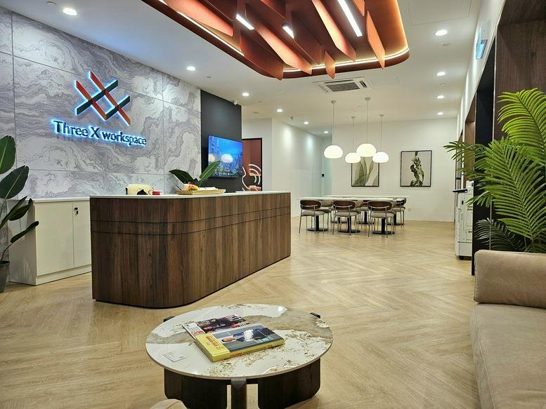 Branded reception area featuring a wood-panelled front desk, marble coffee table, and warm overhead lighting.