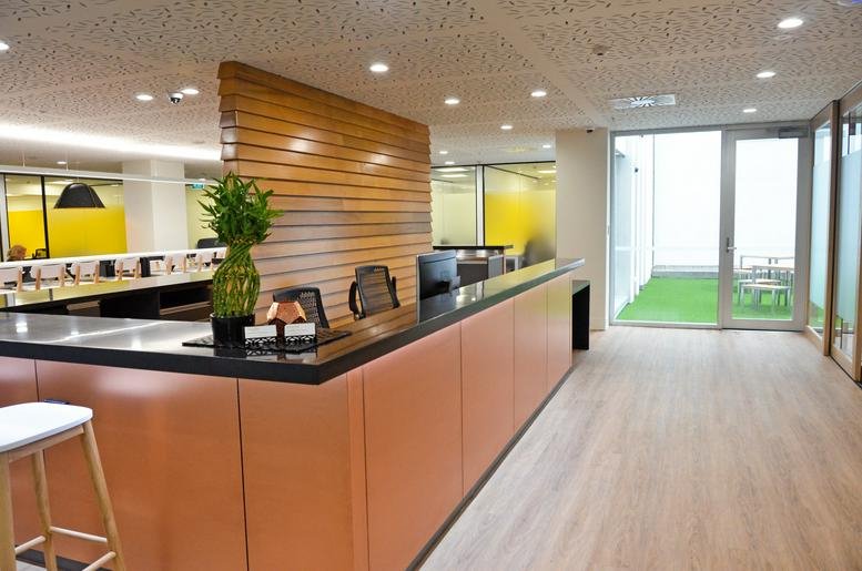 Reception area at Level 2-4, 318 Lambton Quay with wood paneling and a large orange front desk.