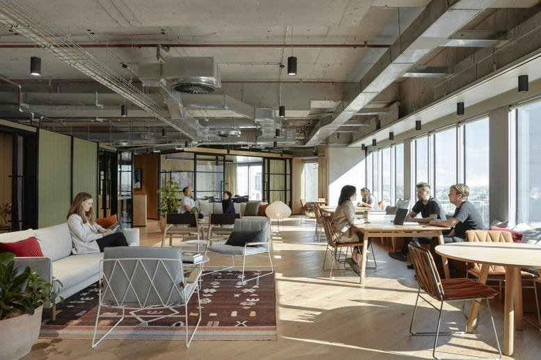 Spacious sun-drenched coworking lounge at Level 2, 580 George Street, Sydney with diverse seating and city views.