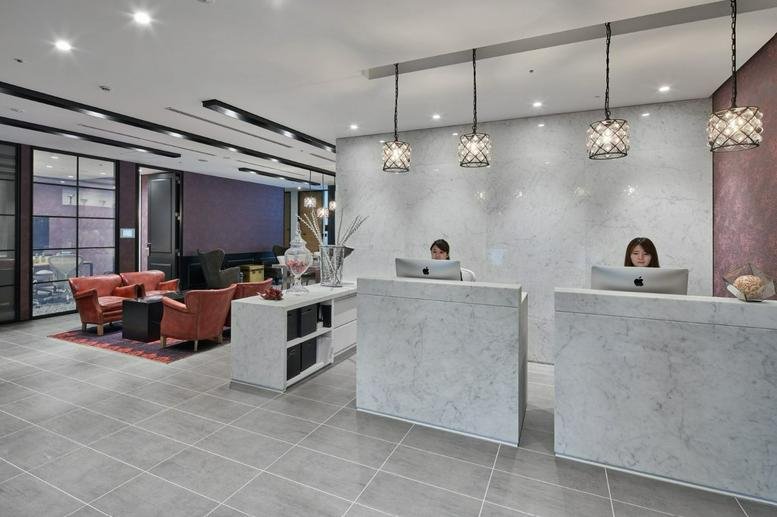 Reception area at Level 21, Shin-Marunouchi Center Building with marble desks and elegant pendant lights.