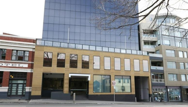 Exterior facade of 85 Macquarie Street, Hobart featuring a modern glass tower above a traditional stone building.