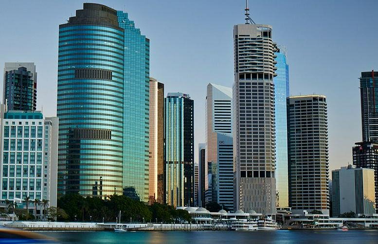 Skyline view of the glass-facade Waterfront Place building at 1 Eagle Street beside the river.