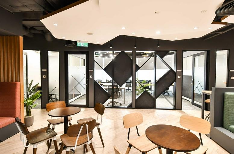 Spacious coworking lounge at Bitexco Financial Tower with geometric ceiling and modern cafe seating.