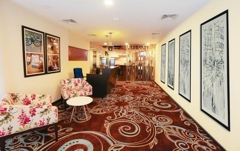 Spacious reception lounge at Level 7, IIFL Towers featuring patterned carpets and framed wall art.