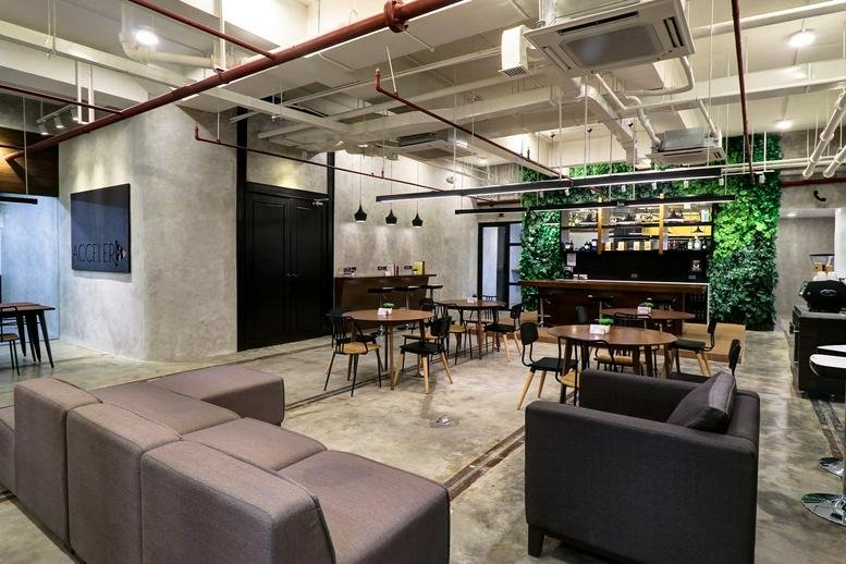 Spacious communal lounge at LG, 111 Paseo de Roxas with industrial ceilings and a lush vertical garden wall.
