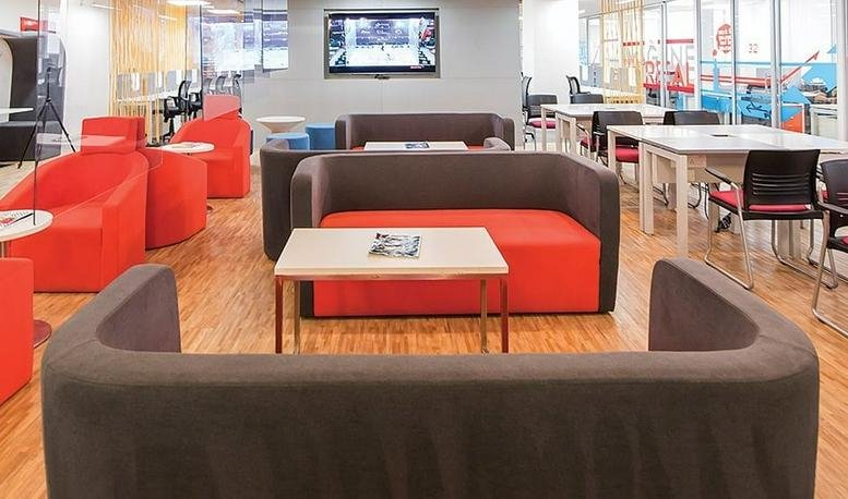 Spacious communal lounge at Lodha Supremus (Opposite Mtnl Off Jvlr) with red and brown sofas and a wall-mounted TV.