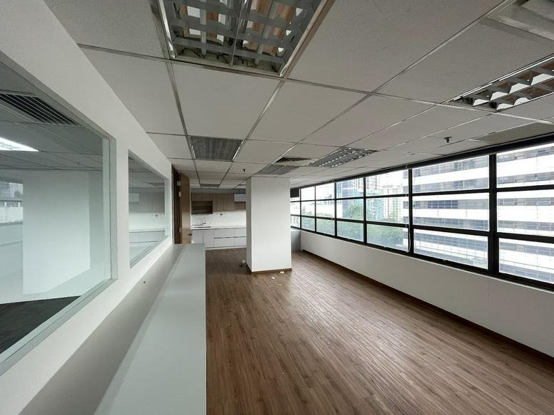 Spacious open-plan office at Faber Tower 2 with wood-style flooring and large windows.