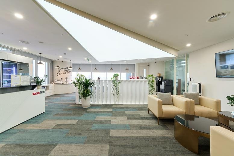 Bright lobby at Lotte Center Hanoi with stylish seating and unique geometric ceiling lighting.
