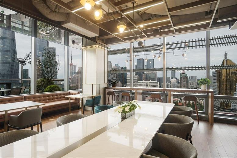 Spacious sunlit lounge at Lujiazui Financial Plaza with a long white table and city views.