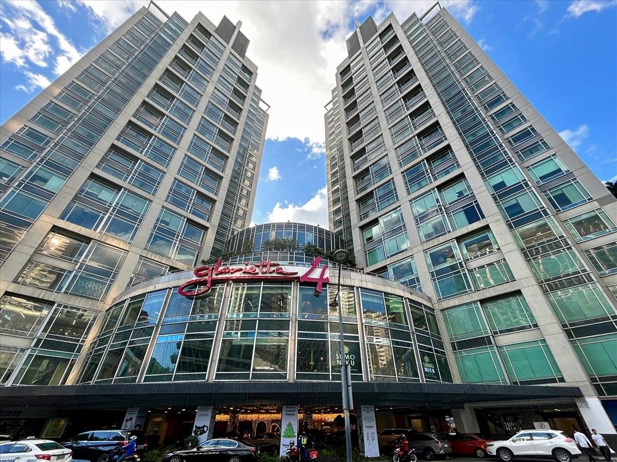 Wide exterior view of the twin towers at Ascott Ayala Center Makati under a blue sky.