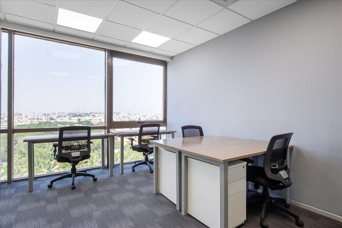 Bright private office at Manjeera Trinity featuring large windows with an expansive city view.