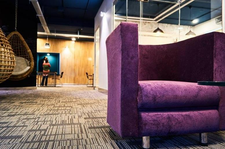 Modern lounge area at Manzoor Plaza, Fazle, A. K. Fazl-ul-Haq Rd with purple velvet armchairs and hanging wicker pods.
