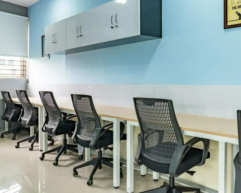 Row of modern mesh ergonomic chairs at a long desk at Marvel Fuego, Magarpatta Road.