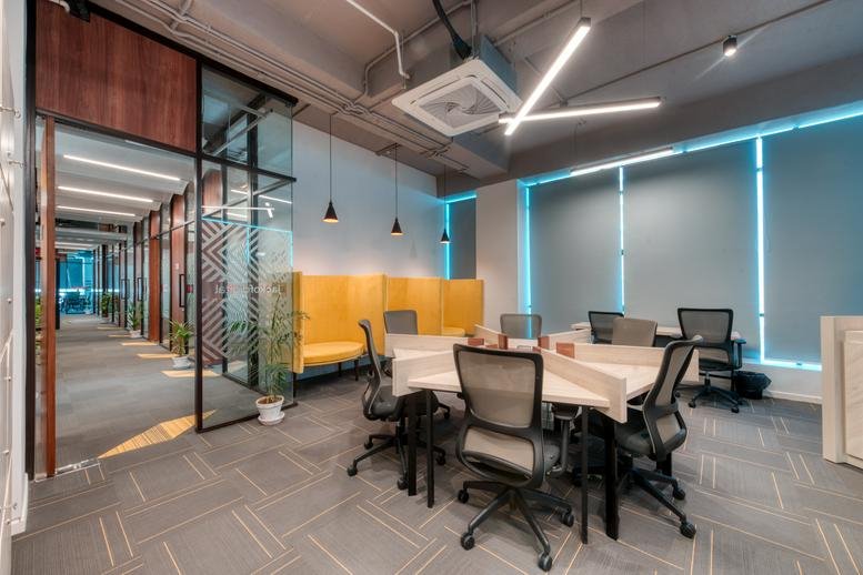 Modern open-plan office at MATF Building with sleek workstations and a bright glass-walled corridor.