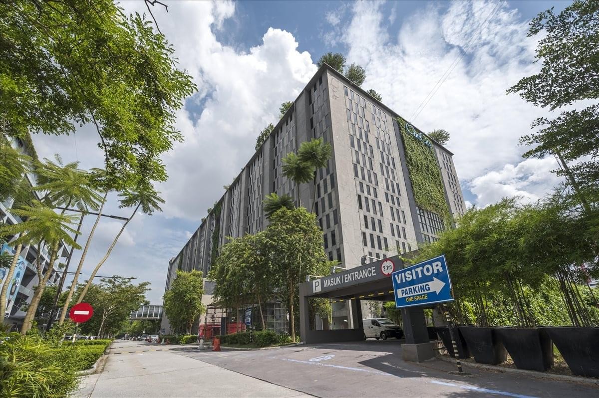 Exterior view of the modern MCT Tower (L8), Sky Park building with vertical greenery and visitor signage.