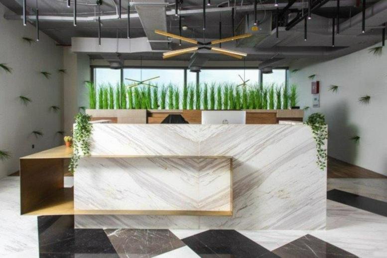 Brightly lit marble reception desk at Media One, Plot 1, Al Falak Street, Media City, Dubai.