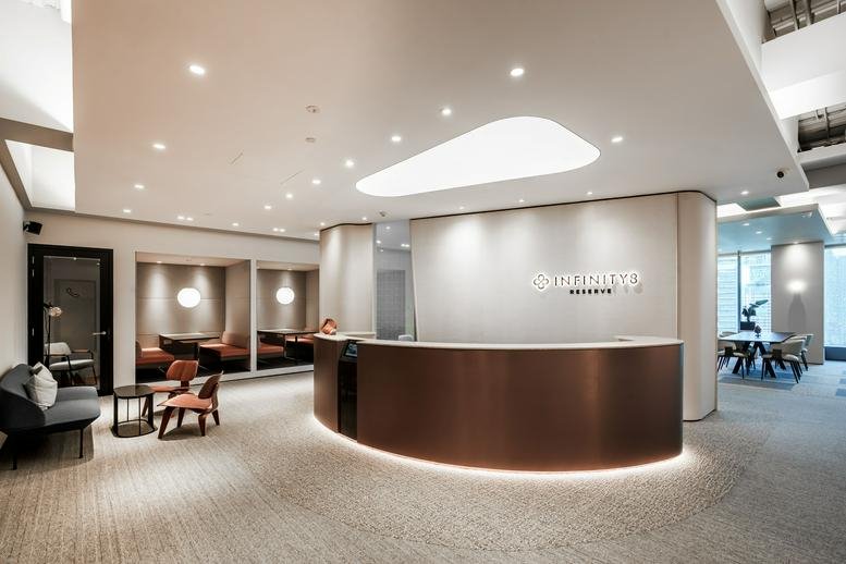 Elegant reception area at Menara Exchange 106 with a curved bronze desk and minimalist lighting.