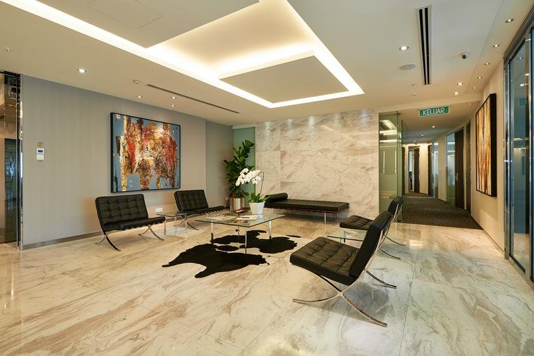 Spacious reception lobby at Menara Maxis, featuring marble floors, modern art, and designer seating.